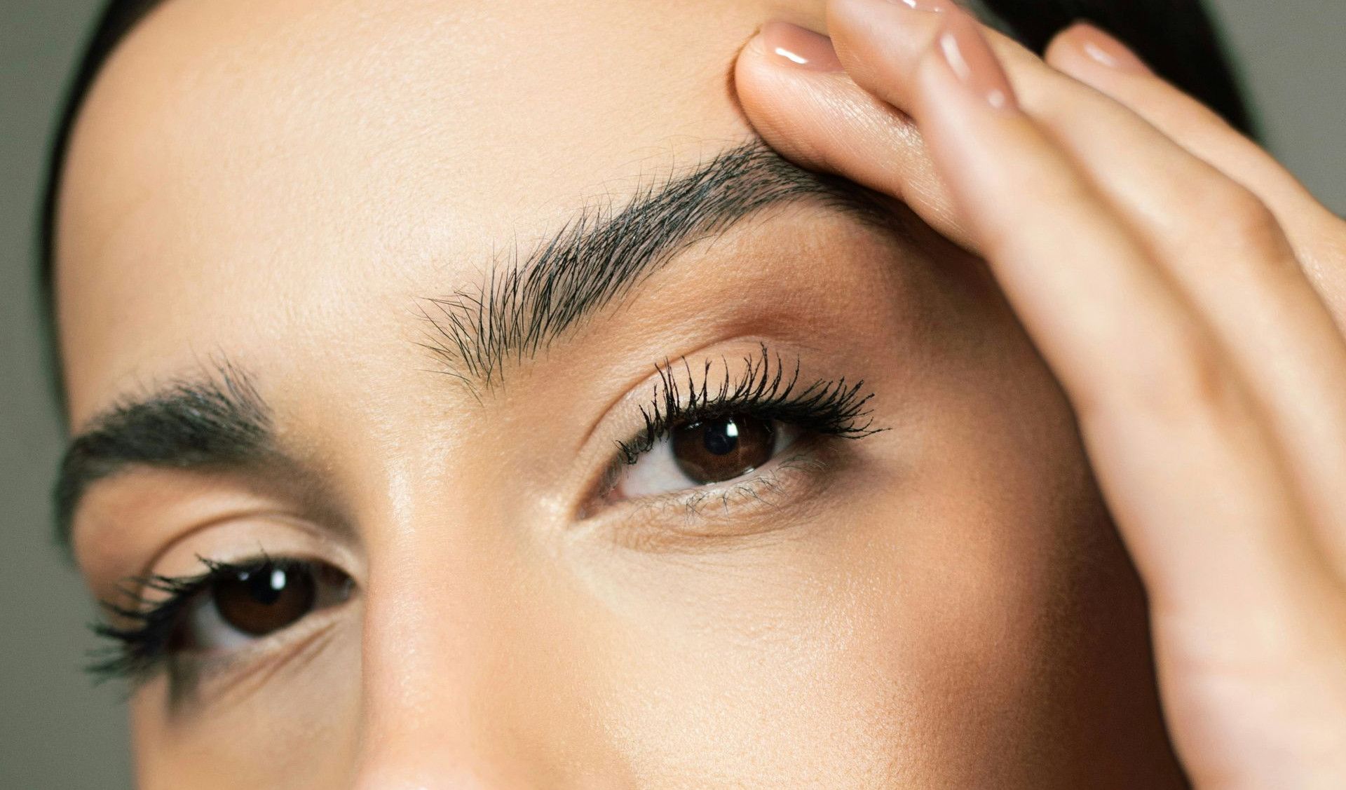 A close up of a woman holding her hand to her face